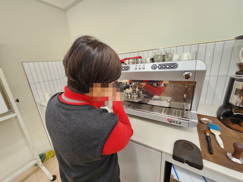 수강생이 에스프레소 머신에 포터필터를 장착하는 모습